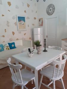 Una mesa blanca y sillas en una habitación con cama en Dimora Chloé en Marsala