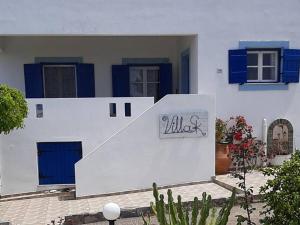 un edificio blanco con puertas azules y un cartel en él en Villa SK en Sissi