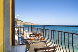 ジャルディーニ・ナクソスにあるLoft Panorama di Naxosの水辺の景色を望むバルコニー(テーブル付)