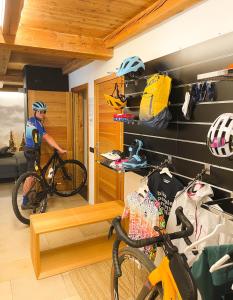 a man with a bike in a room with gear at Alp Apartments - Xavier in Aosta