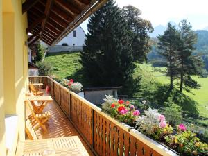 un balcón con bancos y flores en una casa en Gasthof Pension Post "Zenz", en Latschach ober dem Faakersee