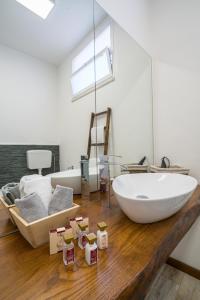 a bathroom with a large white tub on a wooden floor at Loft Panorama di Naxos in Giardini Naxos