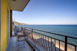 a balcony with a table and chairs and the ocean at Loft Panorama di Naxos in Giardini Naxos