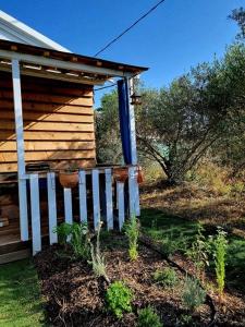 une maison avec une clôture blanche et bleue devant elle dans l'établissement Un chalet dans les oliviers 3 nuits mini, à Nîmes