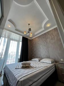 a bedroom with a large bed with a white ceiling at Nukri's Apartment in Batumi