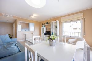 a kitchen and living room with a white table and chairs at Litoral Mar Praia in Portimão