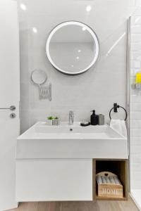 a white bathroom with a sink and a mirror at Dreamy 2 bed apartment by the sea in Paphos
