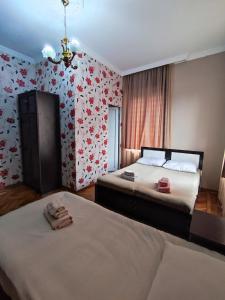 two beds in a room with flowers on the wall at Kobuleti Guest House in K'obulet'i