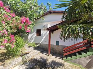 a bench in front of a house with pink flowers at LEA in Bakarac
