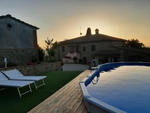 a backyard with a swimming pool and a house at Sunset Valley - A Tuscan Experience in Civitella in Val di Chiana