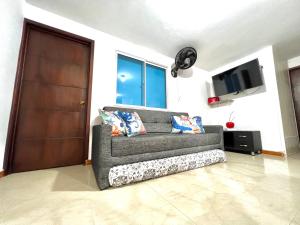 サンタ・マルタにあるApartamentos DNR 201B Rodadero Palanoaのテレビ付きのリビングルームにあるグレーのソファ