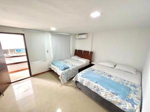 サンタ・マルタにあるApartamentos DNR 201B Rodadero Palanoaのベッド2台と窓のある寝室