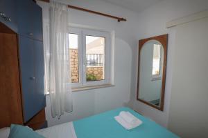 a bedroom with a mirror and a bed and a mirror at Adria Apartment in Hvar