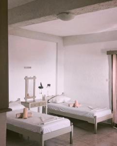 een kamer met 2 bedden en een spiegel bij Mary Popi in Panormos Kalymnos