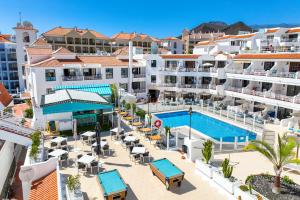a hotel room with a pool and a beach at Club Tenerife Apartments in Los Cristianos