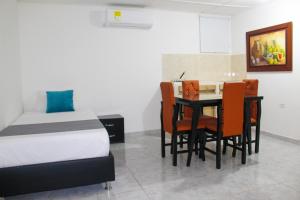 a bedroom with a bed and a table and chairs at Hotel Poblado Suite in Barranquilla