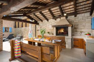 eine Küche mit einem Holztisch und einem Kamin in der Unterkunft Villa Fumica by Villa Plus in Radetići