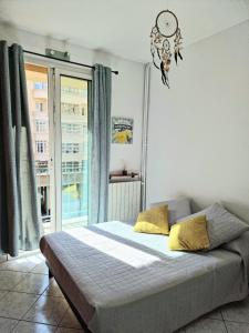 una camera con un letto, una finestra e un lampadario a braccio di La Caisserie Vieux-port / une chambre et balcon a Marsiglia