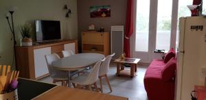 uma cozinha e sala de estar com mesa e cadeiras em Appartement 3 étoiles - 1 chambre Les Becs em Saint-Hilaire-de-Riez
