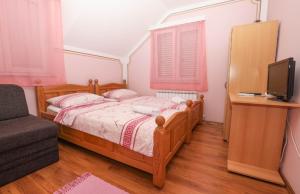 une chambre avec un lit, une télévision et une chaise dans l'établissement Rooms Odmaralište Jablan, à Senj