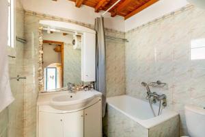 een badkamer met een wastafel, een bad en een toilet bij Casa Paraportiani View Mykonos Town House in Mykonos-stad