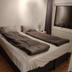 a large bed in a room with a window at Nydelig leilighet, Free parking near sentrum in Bergen