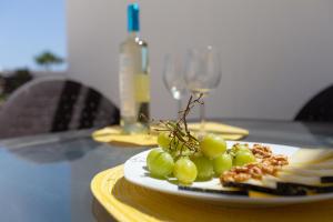 a plate of grapes and cheese on a table at Right on the beach in Benalmádena
