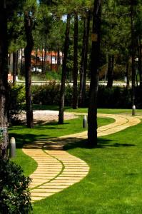 a walkway in a park with trees and grass at Miravillas Hotel in Praia de Mira