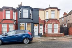 a blue car parked in front of a row of houses at Spaces by Hexagon in Liverpool
