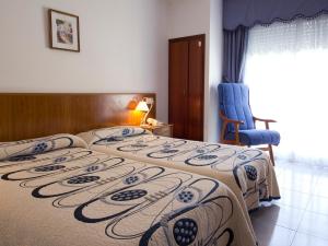 a bedroom with two beds and a chair and a window at Hotel Restaurante Xaneiro in Melide