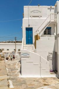 a white building with a blue door and stairs at Casa Paraportiani View Mykonos Town House in Mikonos