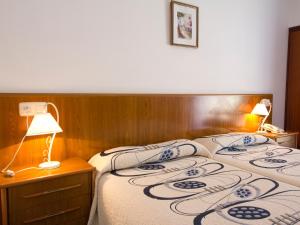 a bedroom with a bed and a lamp on a table at Hotel Restaurante Xaneiro in Melide