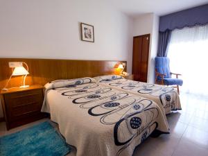 a bedroom with a large bed with a blanket at Hotel Restaurante Xaneiro in Melide