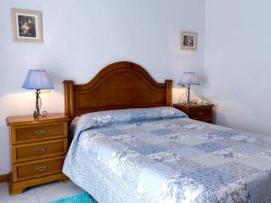 a bedroom with a bed and two night stands with lamps at Hotel Restaurante Xaneiro in Melide