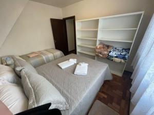 a room with two beds and a couch and shelves at Apartamento para 9 pessoas - Blumenhaus 201 - uma quadra da Rua Coberta! in Gramado