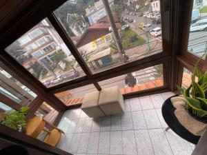 a view of a living room with a large window at Apartamento para 9 pessoas - Blumenhaus 201 - uma quadra da Rua Coberta! in Gramado