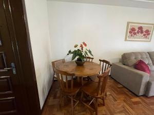 a living room with a table and a couch at Apartamento para 9 pessoas - Blumenhaus 201 - uma quadra da Rua Coberta! in Gramado