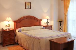 a bedroom with a large bed and two night stands at Hotel Restaurante Xaneiro in Melide
