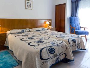 a bedroom with a bed with a blanket on it at Hotel Restaurante Xaneiro in Melide