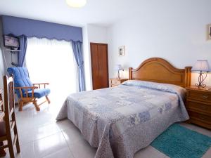 a bedroom with a bed and a chair and a window at Hotel Restaurante Xaneiro in Melide