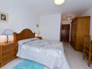 a bedroom with a bed and a wooden dresser at Hotel Restaurante Xaneiro in Melide