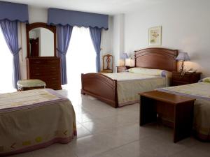 a hotel room with two beds and a mirror at Hotel Restaurante Xaneiro in Melide
