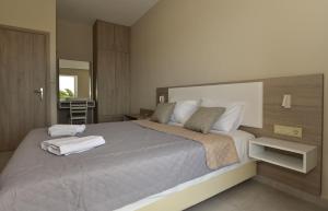 a bedroom with a large bed with two towels on it at Flisvos Rooms in Palaiochora