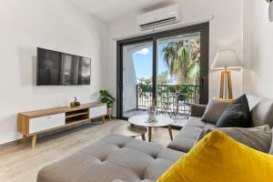 a living room with a couch and a tv at Dreamy 2 bed apartment by the sea in Paphos