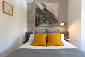 a bedroom with a bed with yellow pillows at Cute apartment oceanfront in Benalmádena