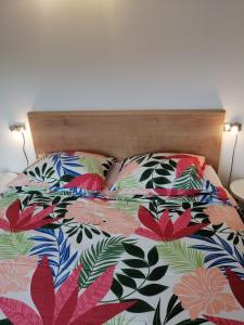 uma cama com um edredão floral e 2 almofadas em Apartments Iris em Marina