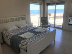 ein Schlafzimmer mit einem Bett mit Blick auf den Strand in der Unterkunft Angeiras Beach House - Porto - Villa by the Sea in Lavra