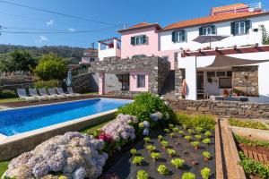 een villa met een zwembad en een huis bij Villa Casa Das Orquideas by Villa Plus in Estreito da Calheta