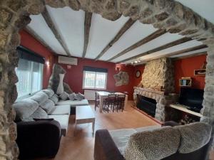 a living room with a couch and a stone fireplace at Chalet independiente con amplio jardín y barbacoa AT - CC-00678 in Puerto Rey