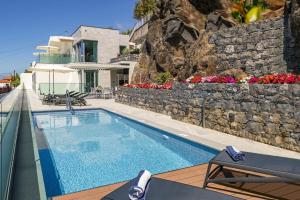 a swimming pool on the side of a house at Villa Grandview by Villa Plus in Funchal